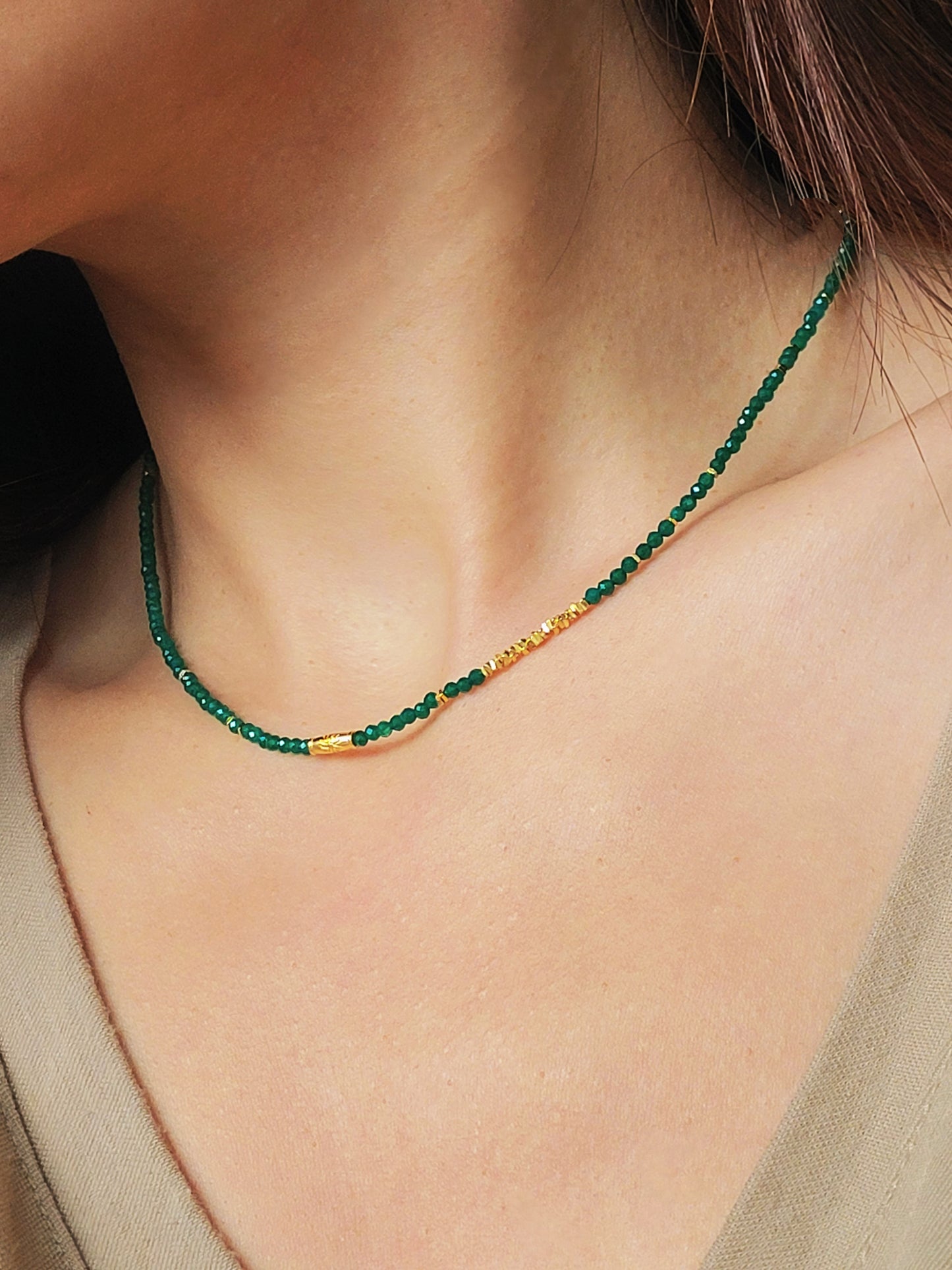 A close-up of a woman&#39;s neck wearing a Green Onyx Beaded Necklace with 18k Gold Vermeil beads, showcasing an elegant minimalist design perfect for everyday wear or special occasions.