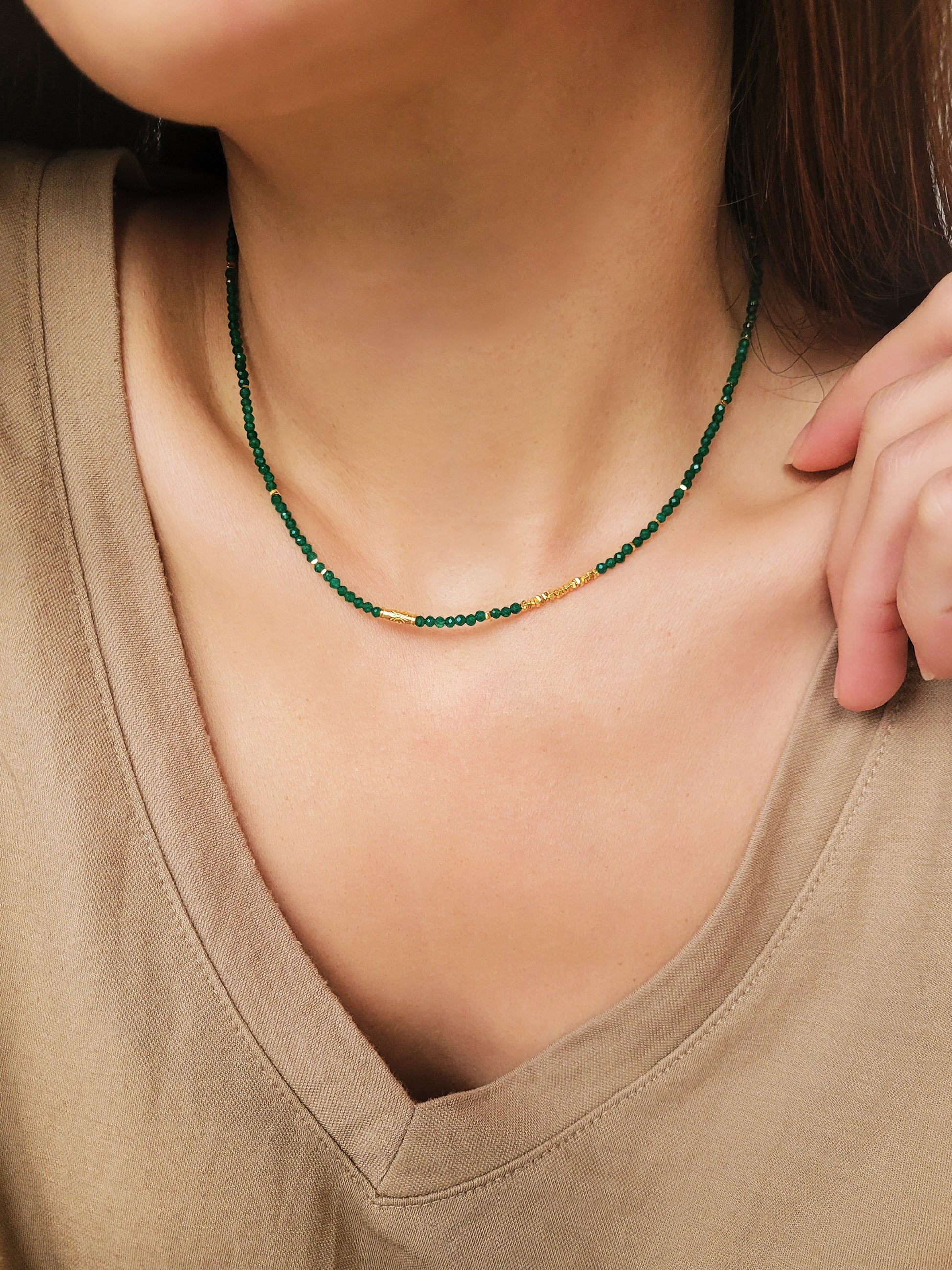 A close-up of a woman&#39;s neck wearing a Green Onyx Beaded Necklace with 18k Gold Vermeil beads, showcasing an elegant minimalist design perfect for everyday wear or special occasions.