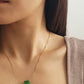 A natural green jade bead necklace with a polished finish, strung on a gold-plated sterling silver chain, offering a minimalist and elegant style.