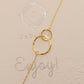 Delicate gold interlocking circle bracelet showcased on a paper, highlighting its simple and timeless design, perfect for everyday wear or gifting