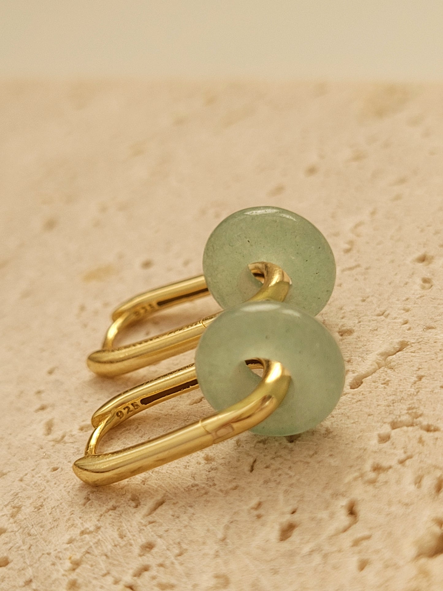 Close-up of a pair of green jade link hoop earrings, showcasing their elegant and minimalist design.