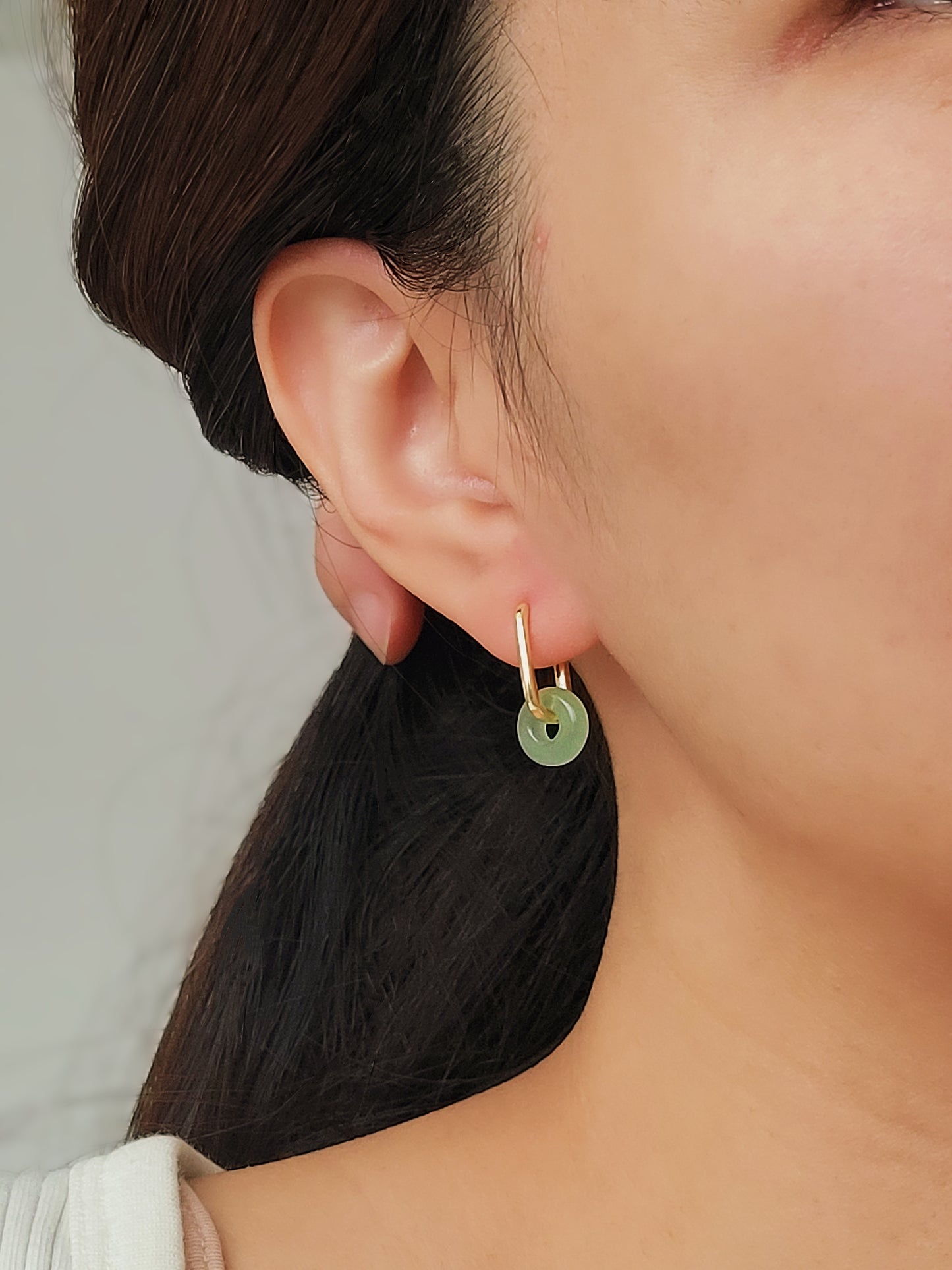 Close-up of a pair of green jade link hoop earrings, showcasing their elegant and minimalist design.