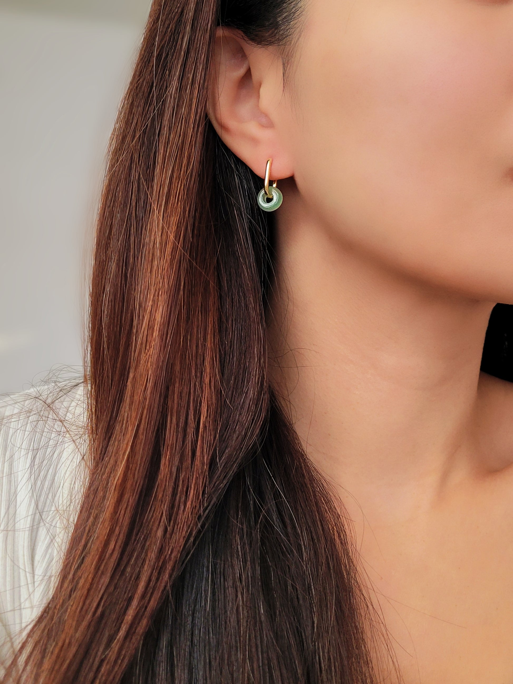 Close-up of a pair of green jade link hoop earrings, showcasing their elegant and minimalist design.