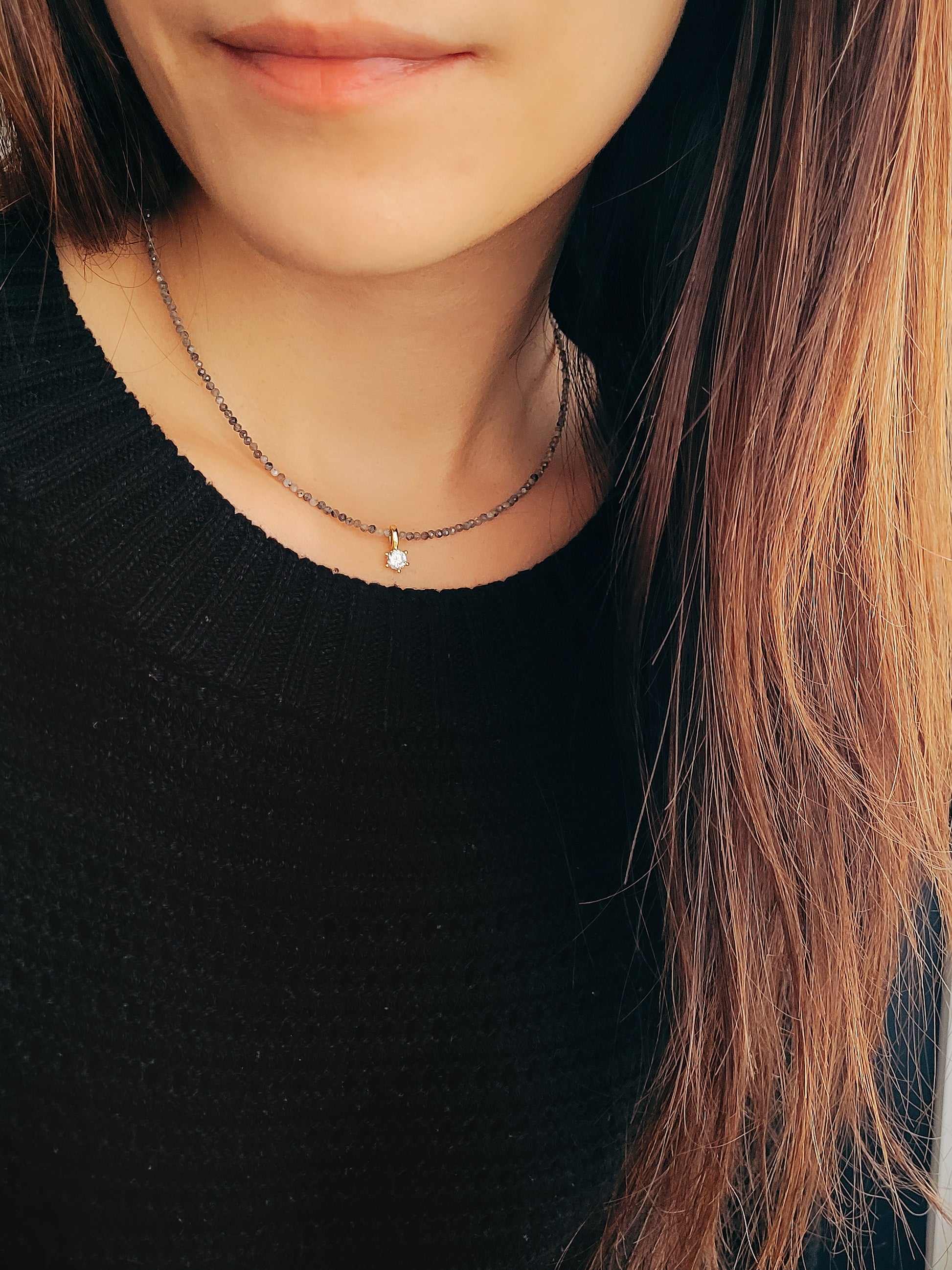 Minimalist gemstone necklace with gray labradorite beads and a sparkling diamond-like pendant.