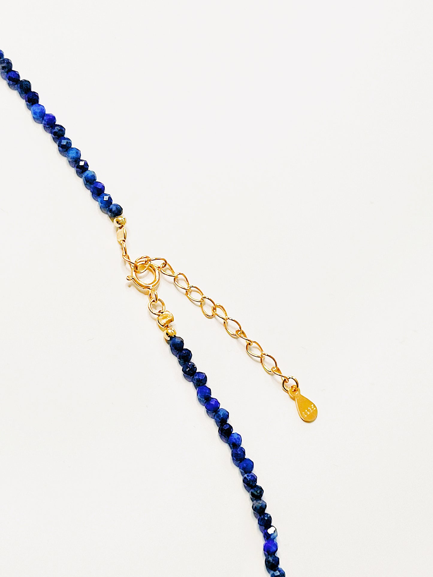 Close up of a blue lapis lazuli beaded necklace featuring a mix of gemstones and elegant gold vermeil beads. Handcrafted for a unique, luxurious look. Perfect for any occasion. Stand out in style with this exquisite piece!