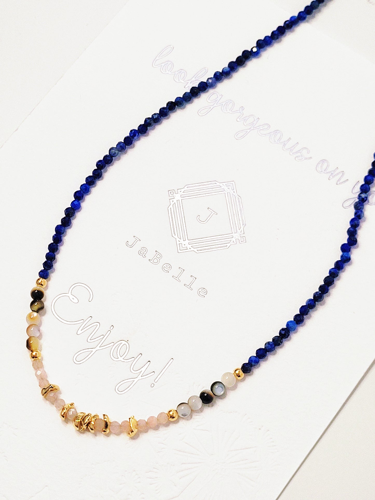 Close up of a blue lapis lazuli beaded necklace featuring a mix of gemstones and elegant gold vermeil beads. Handcrafted for a unique, luxurious look. Perfect for any occasion. Stand out in style with this exquisite piece!