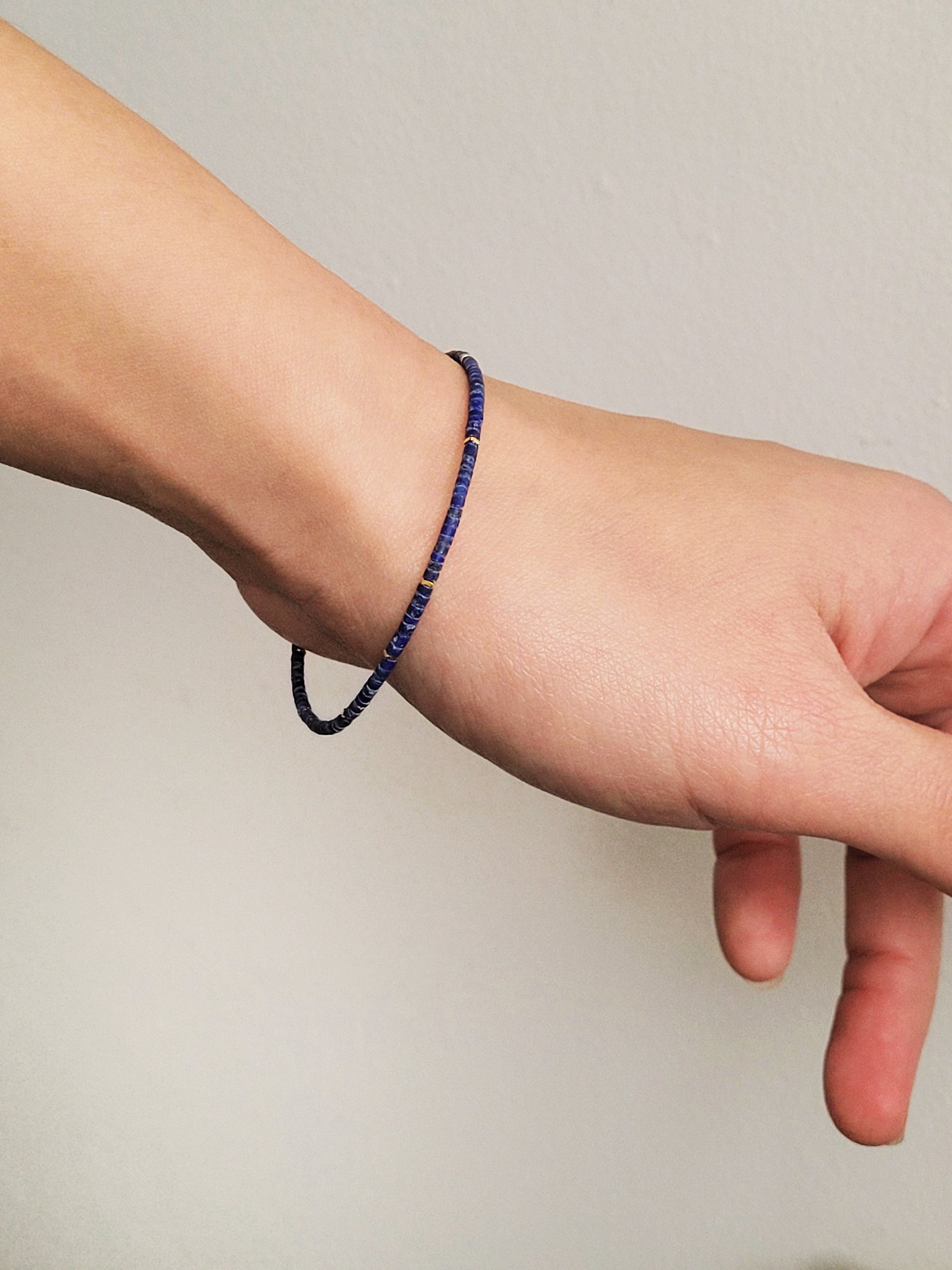 A minimalist gemstone bracelet featuring high-quality 2mm royal blue Lapis Lazuli beads paired with 18k gold vermeil accents, creating a delicate and timeless design perfect for stacking or wearing alone.