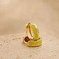 A pair of Green Enamel Huggie hoops in gold plated sterling silver on an aesthetic colored stone, dainty minimalist everyday earrings.