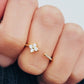 Close-up of a woman's hand showcasing a dainty gold Clover ring featuring four brilliant diamonds.