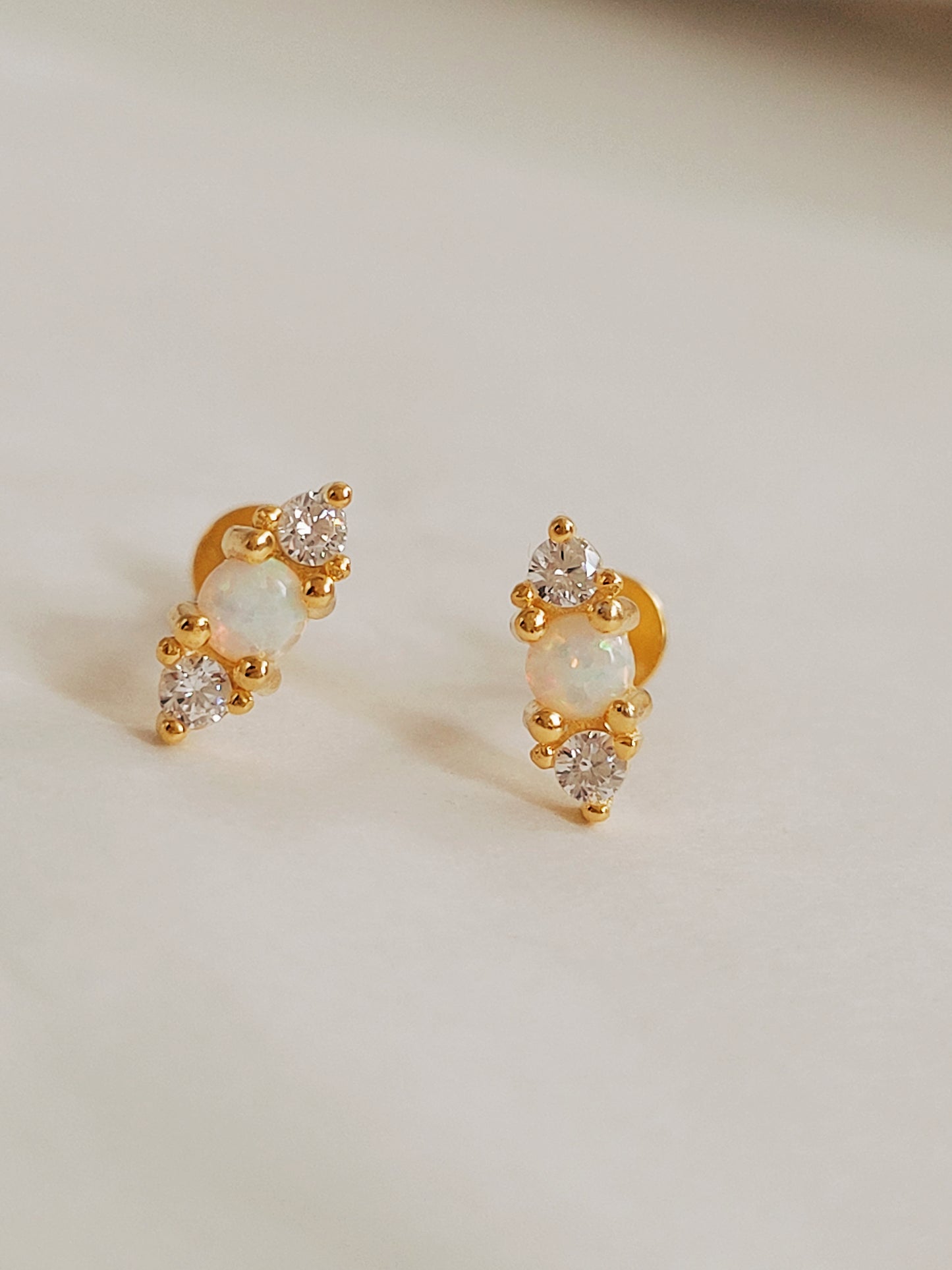 Natural opal earrings with sparkling zirconia and gold accents. Simple and elegant opal stud earrings with a touch of sparkle.