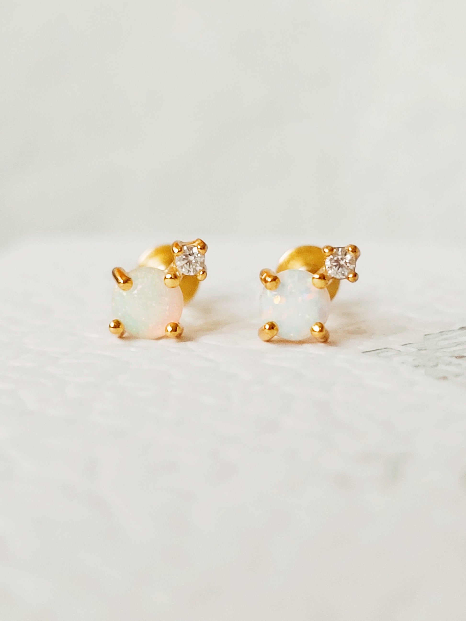 Mini round opal stud earrings in 18K gold vermeil on a white background, emphasizing the minimalist design.