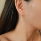 Woman wearing gold threader earrings with sterling silver nuggets, showing the long drop length. A unique birthday jewellery gift.