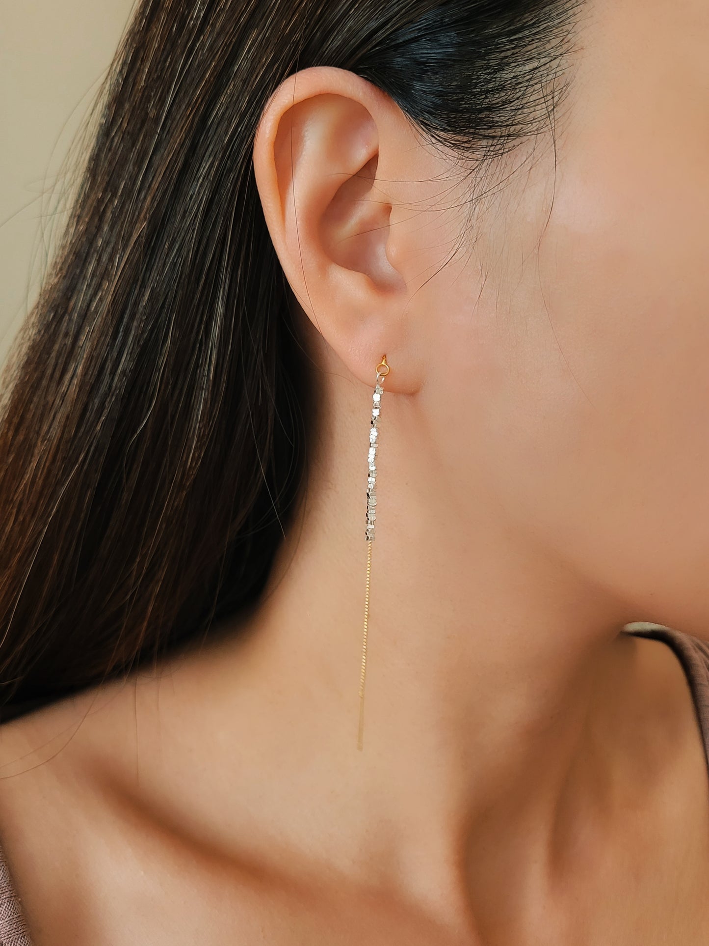 Woman wearing gold threader earrings with sterling silver nuggets, showing the long drop length. A unique birthday jewellery gift.