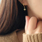 Close-up of a girl wearing a gold star drop earring, minimalist and stylish