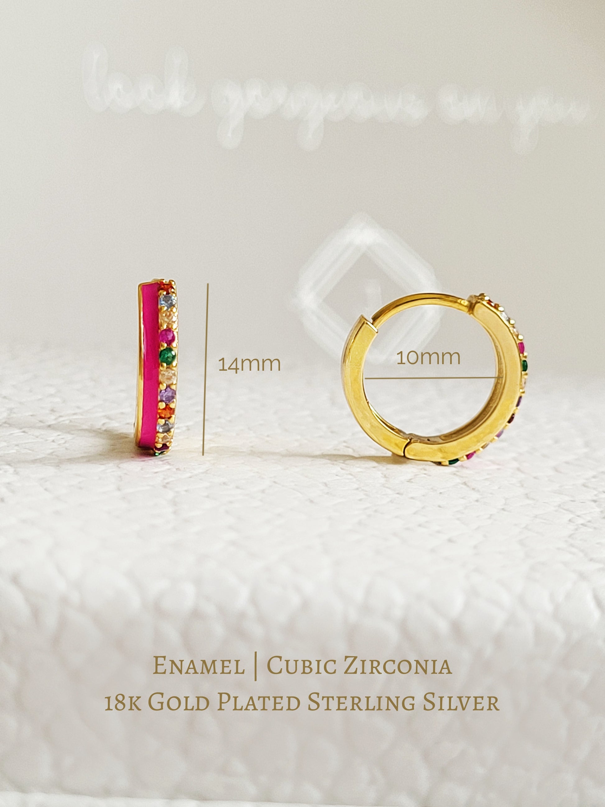 Pair of pink enamel huggie hoop earrings with multicolor cubic zirconia gemstones set in 18k gold plated sterling silver, displayed on a white background.