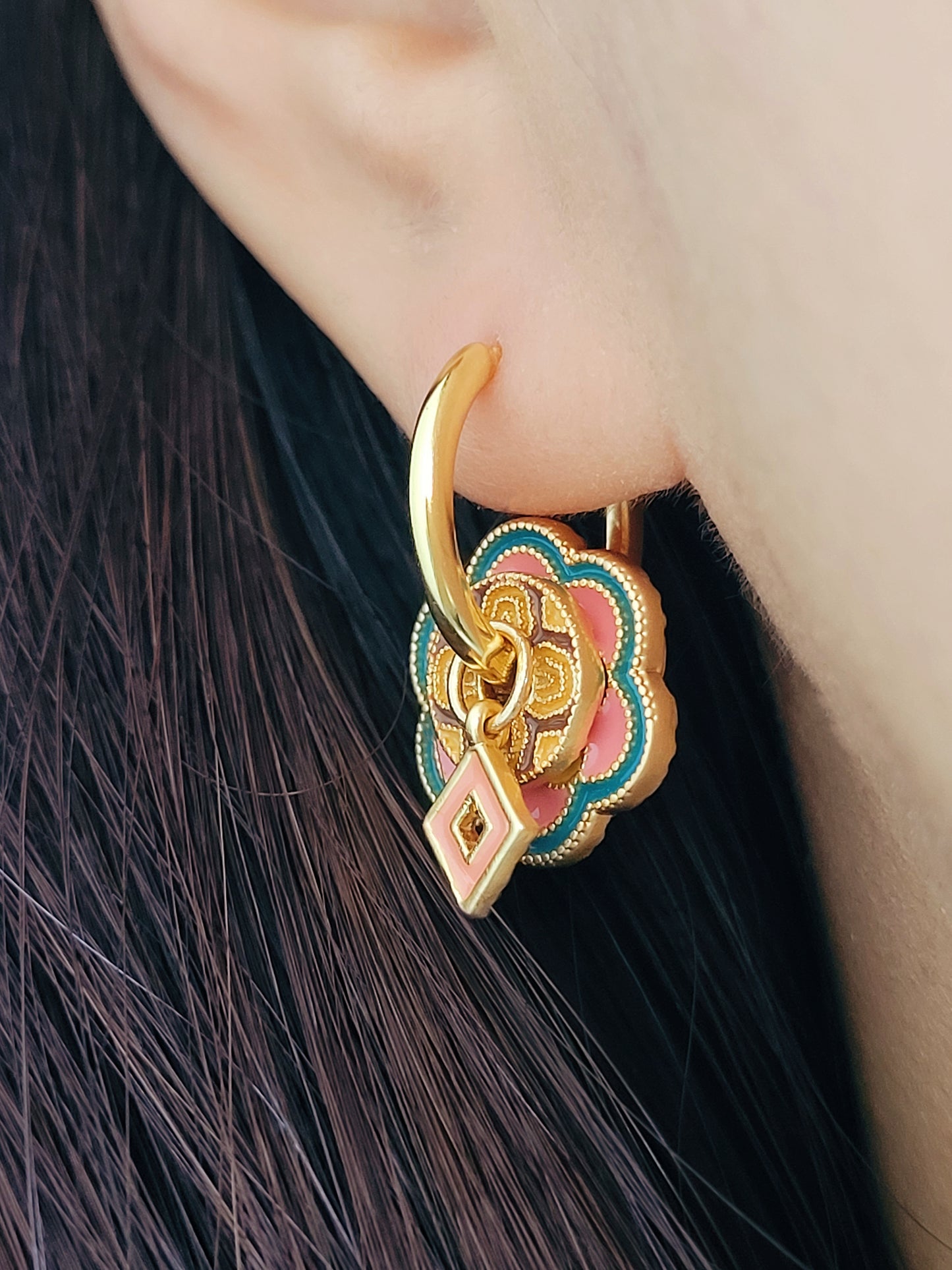 Close up of unique tile pattern enamel hoop earrings