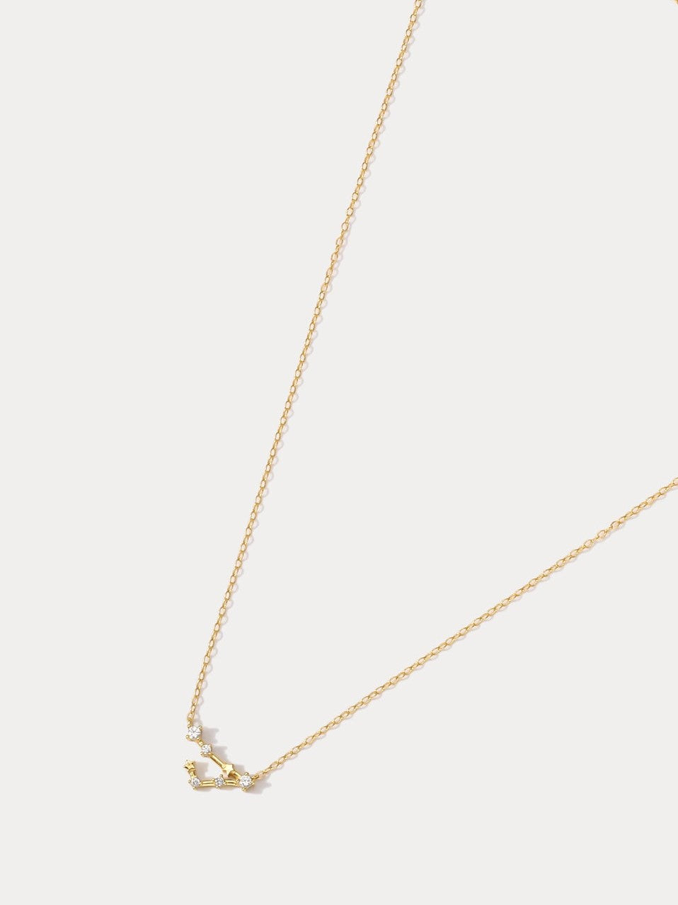 A dainty gold necklace with a pendant featuring a stylized Pisces zodiac constellation sign with sparkling zircons, thoughtful jewellery gift for her.