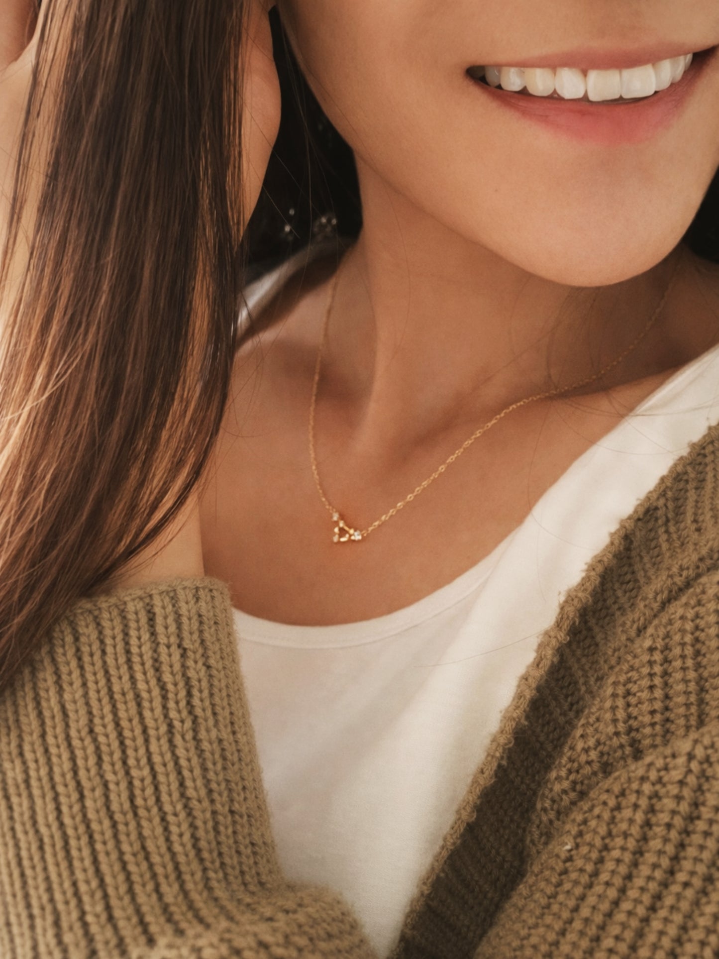 Close-up of a woman wearing an Pisces necklace showcasing the luxury aesthetic and pendant scale. Crafted in gold vermeil, a perfect jewellery gift for her.