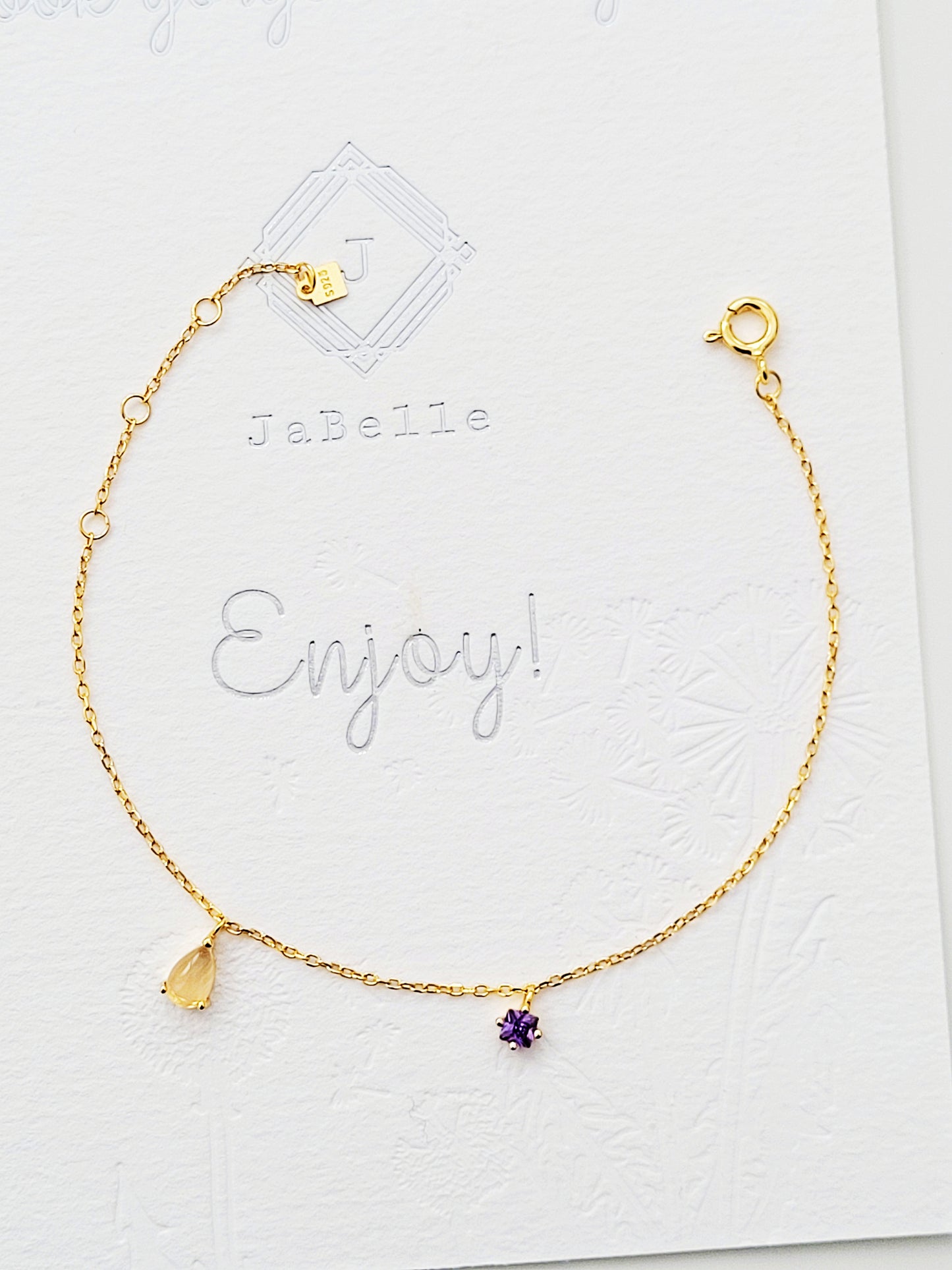 Enjoy a luxurious gold bracelet featuring a stunning purple amethyst stone and golden rutilated quartz.