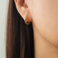 Woman wearing sapphire blue star huggie earrings, minimalist and delicate style