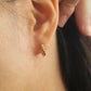 Close up of a delicate blue star earrings on ear, best anniversary gift for her