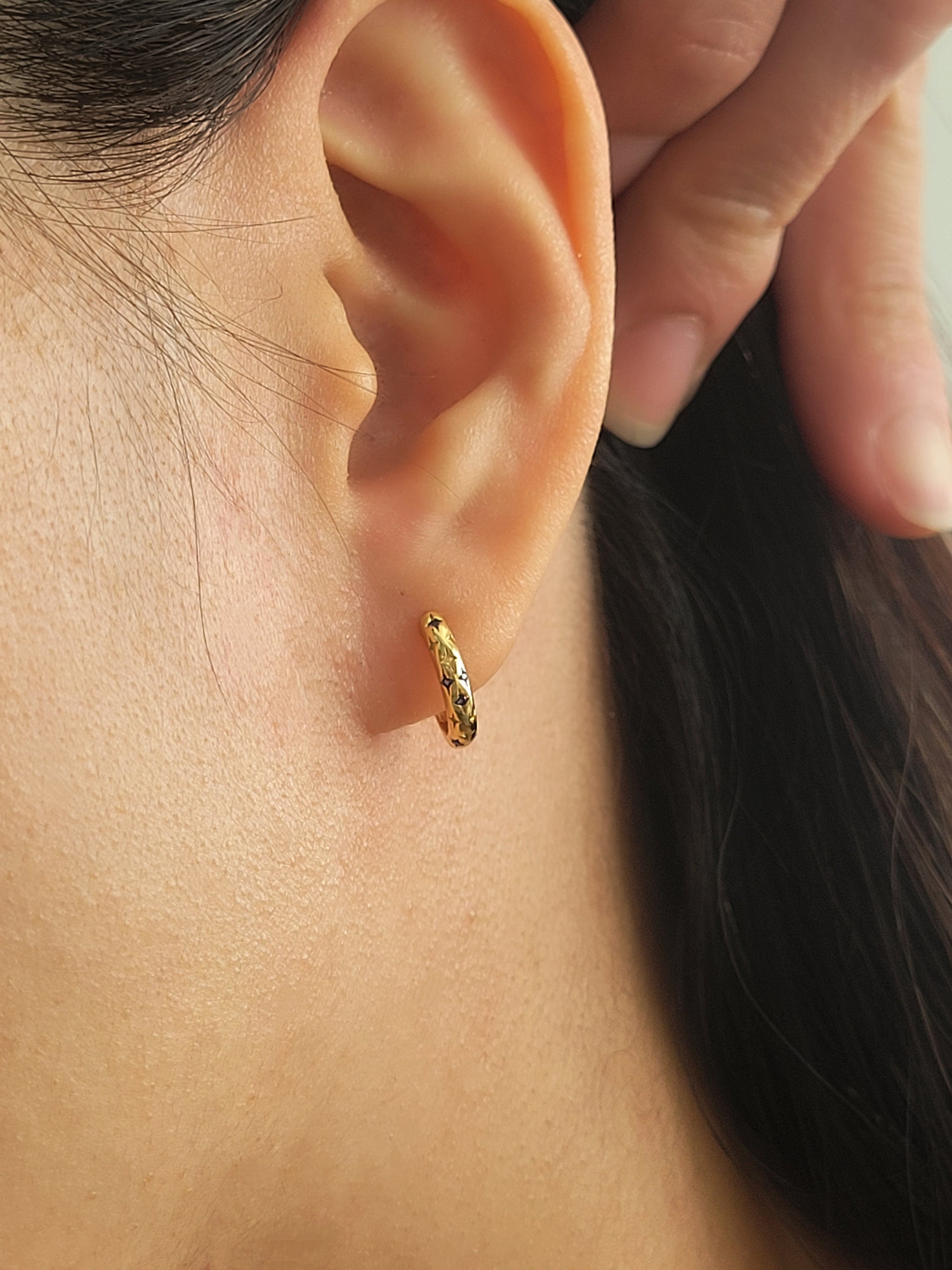 Close up of a delicate blue star earrings on ear, best anniversary gift for her