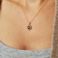 This image features a close-up view of a woman wearing a delicate and elegant Sapphire CZ diamond necklace. The necklace has a gold chain that provides a classic and sophisticated touch.