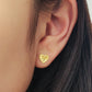 Close-up of an ear wearing a minimalist elegant gold heart stud earring.