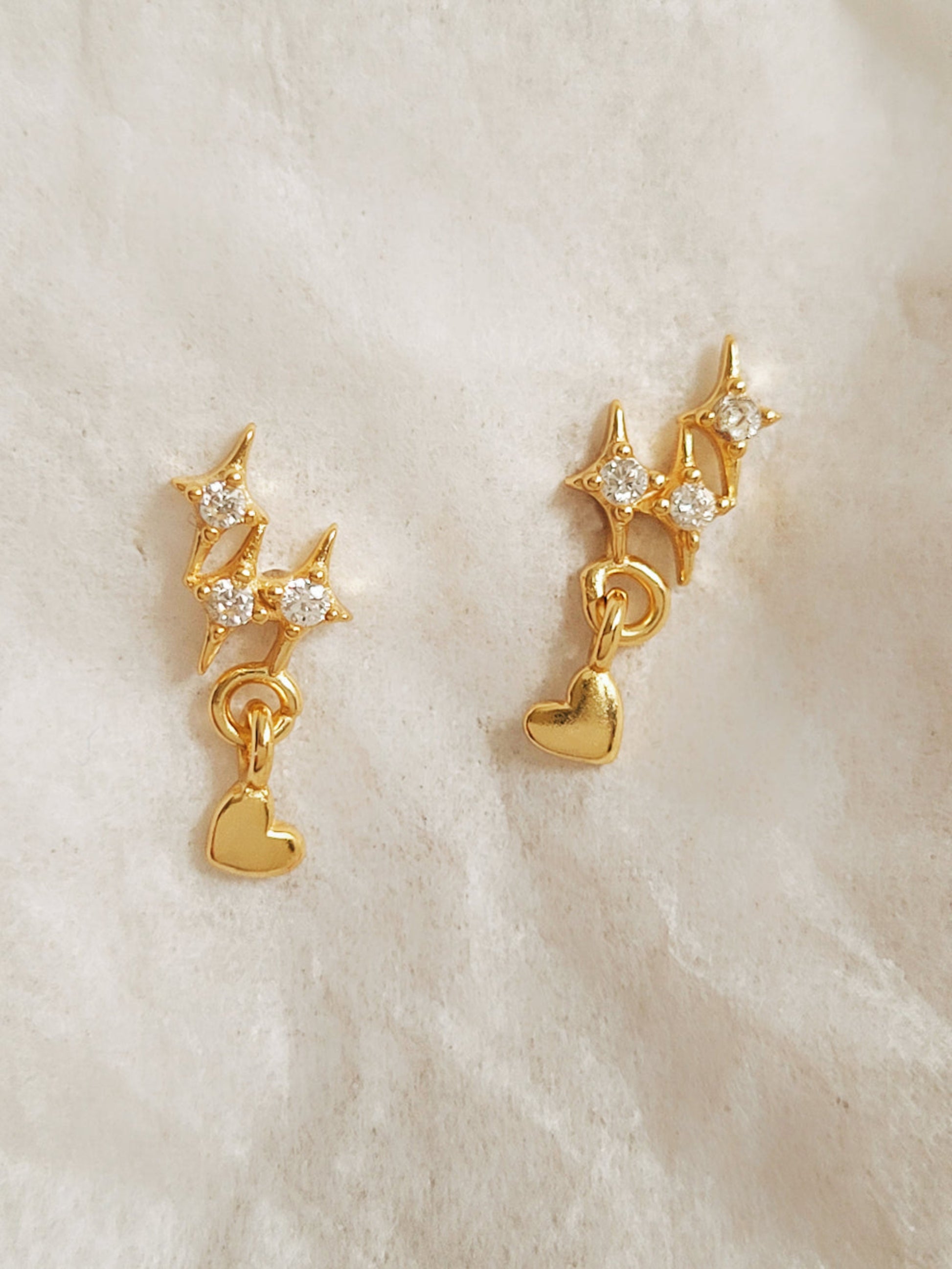 Dainty gold star stud earrings with heart charm crafted in gold plated sterling silver with sparkling cz diamond. Perfect gift for birthdays or anniversaries.