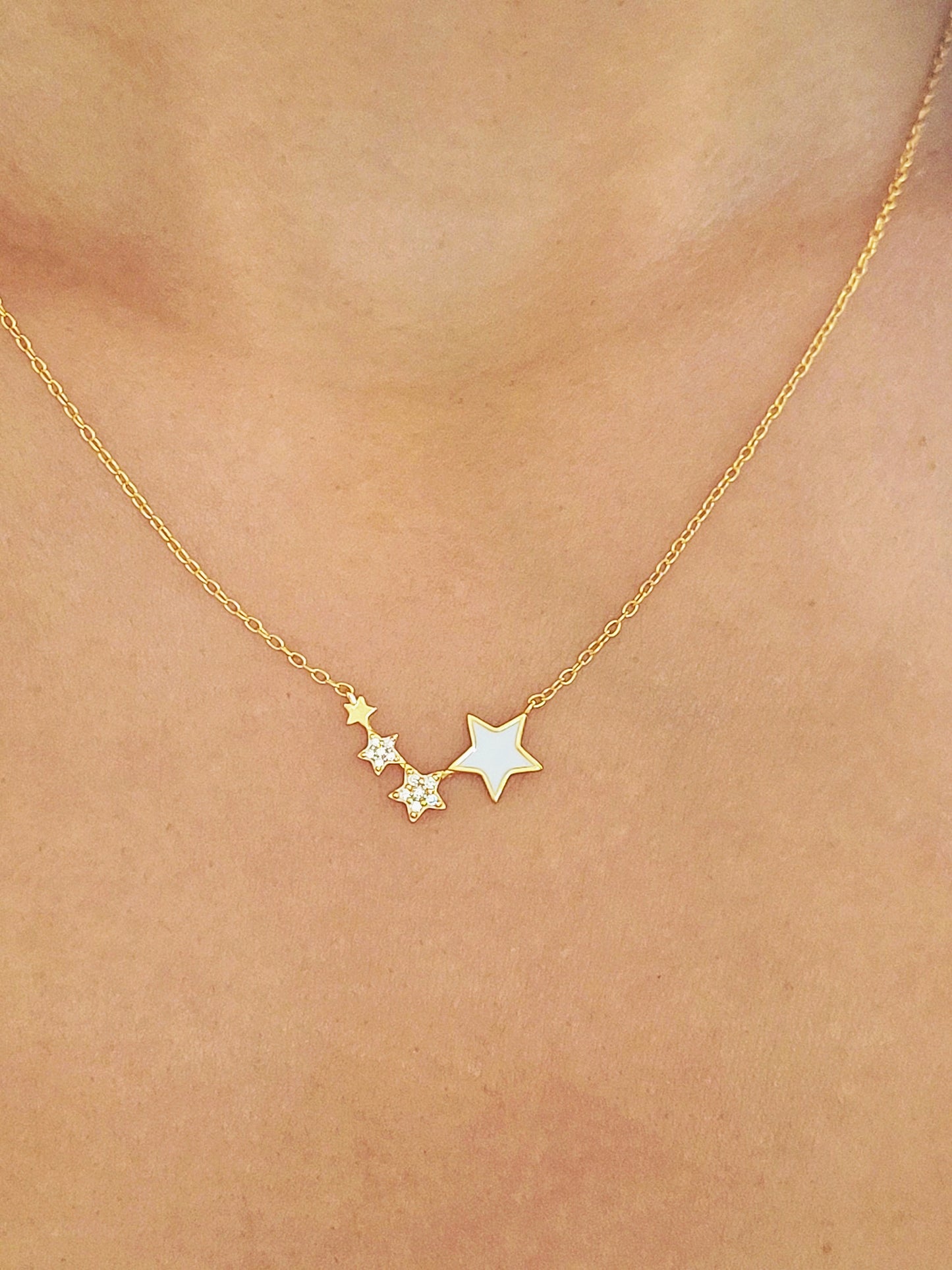 A woman wearing the Stars Pendant Necklace with 4 little stars.