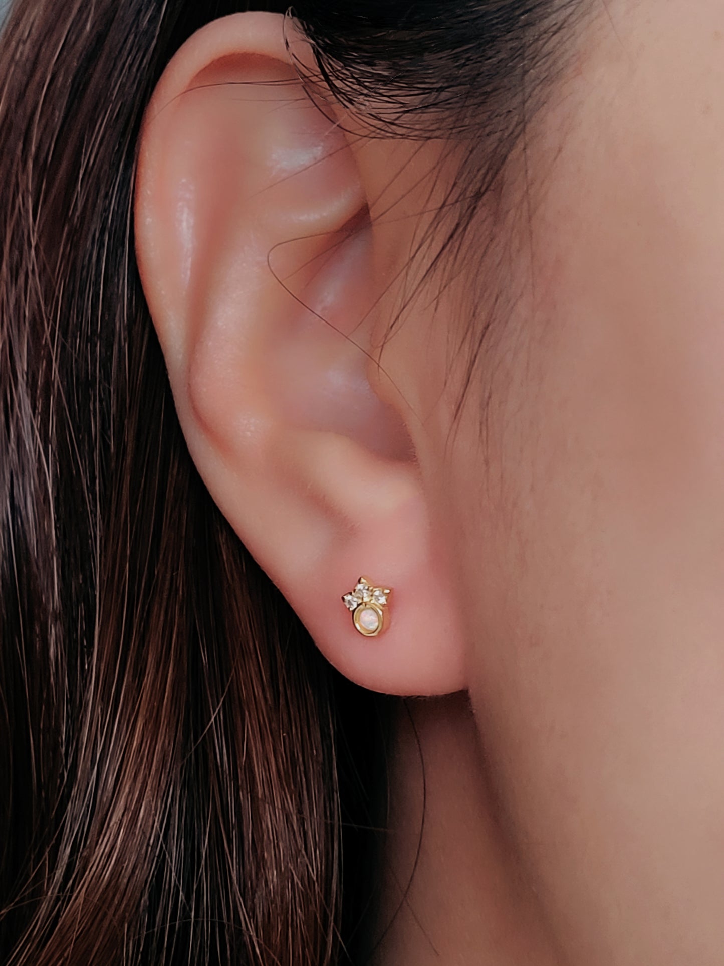 A model wearing a dainty Crown Opal Stud Earrings with screw back closure for comfortable daily wear. Crafted in sterling silver with 18k gold plated and adorned with diamond accents.