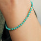 Close up of a woman's wrist wearing a Gold Turquoise beaded bracelet. Crafted in high quality natural turquoise gemstone intersecting with gold vermeil beads.