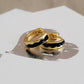 Gold hoop earrings with black enamel on a white surface