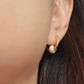 Close-up of peach white Enamel Ball Drop Huggie Earrings, showcasing its fun and minimalist design for a cute and playful look.