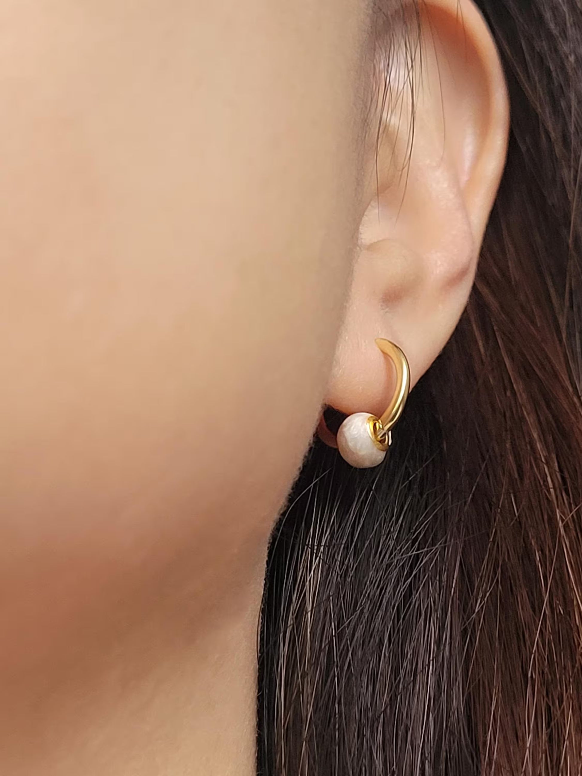 Close-up of peach white Enamel Ball Drop Huggie Earrings, showcasing its fun and minimalist design for a cute and playful look.