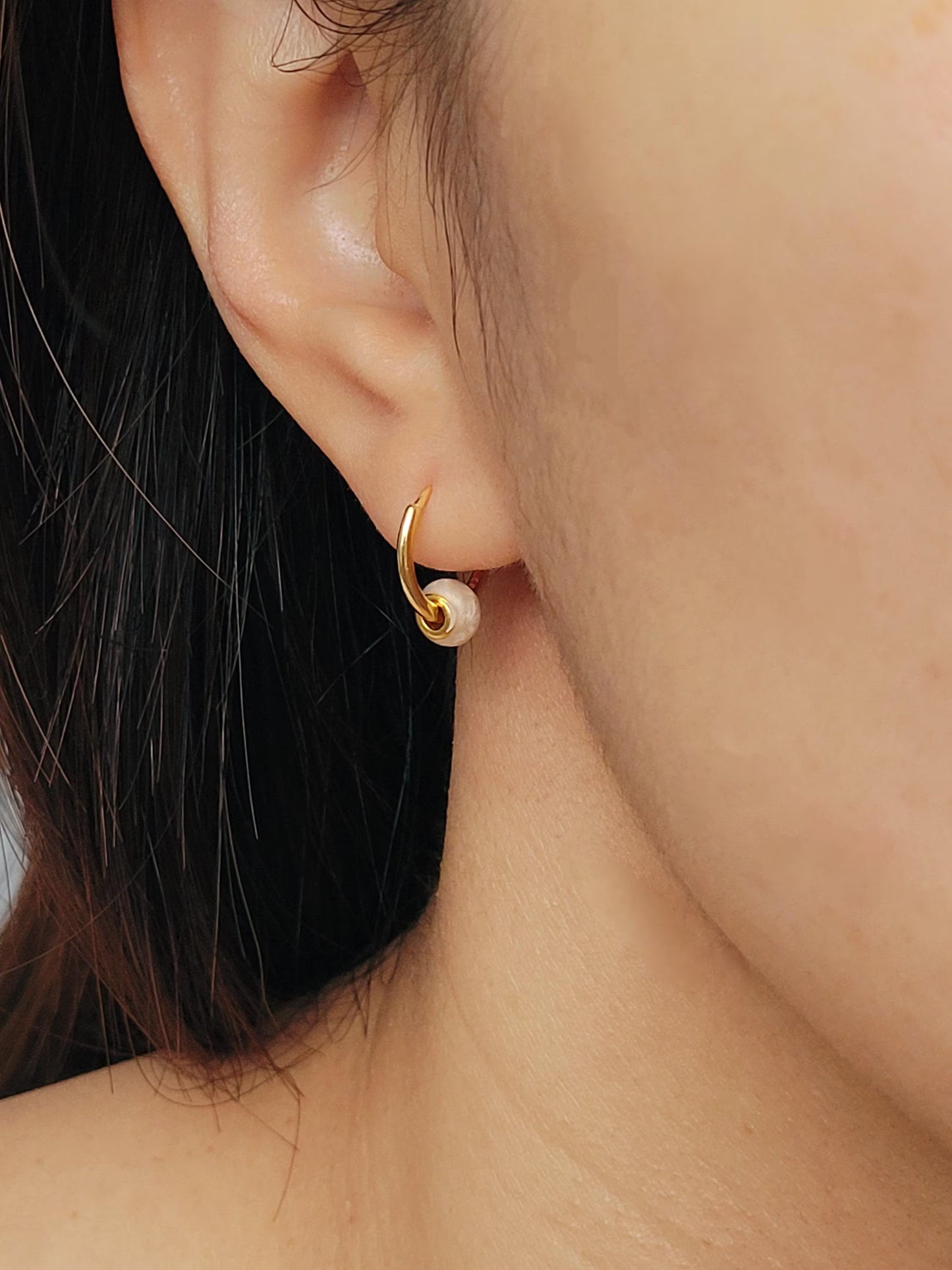 Close-up of peach white Enamel Huggie Earrings, showcasing its fun and minimalist design for a cute and playful look.