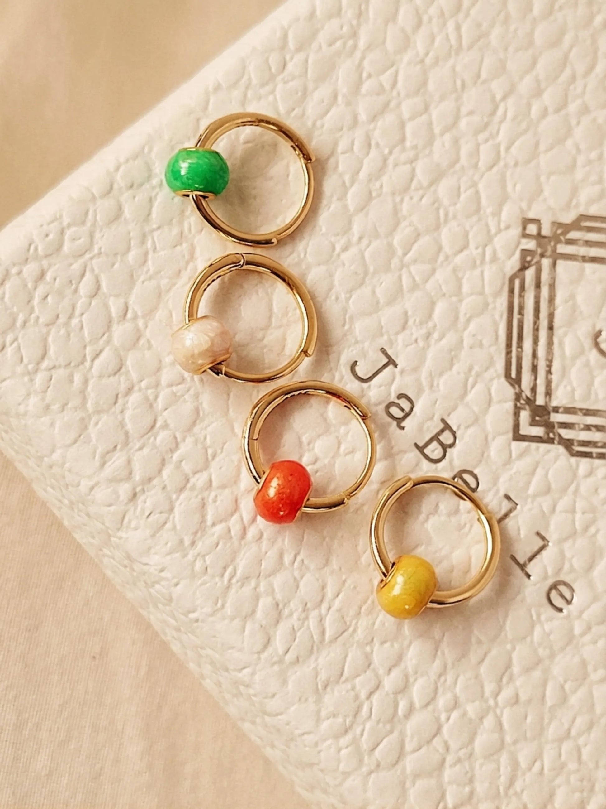 Set of four colors minimal drop hoop earrings featuring colorful enamel beads. 