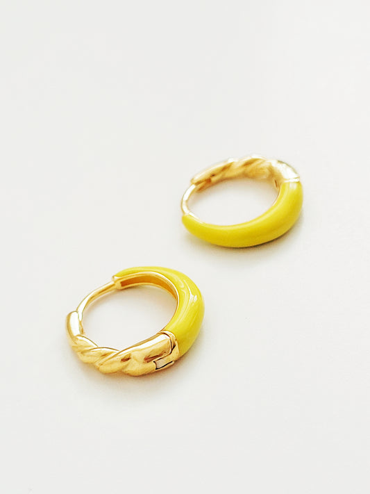 Pair of yellow enamel gold hoop earrings on a white background