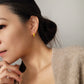 Model wearing small yellow and gold enamel hoop earrings, showcasing their elegant and lightweight design.