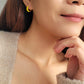 Model wearing small yellow and gold enamel hoop earrings, showcasing their elegant and lightweight design.