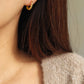 Model wearing small yellow and gold enamel hoop earrings, showcasing their elegant and lightweight design.