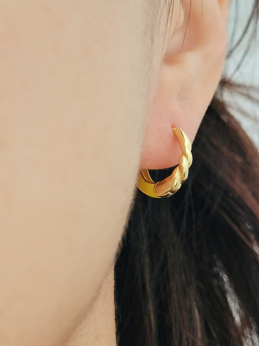 Model wearing small yellow and gold enamel hoop earrings, showcasing their elegant and lightweight design.