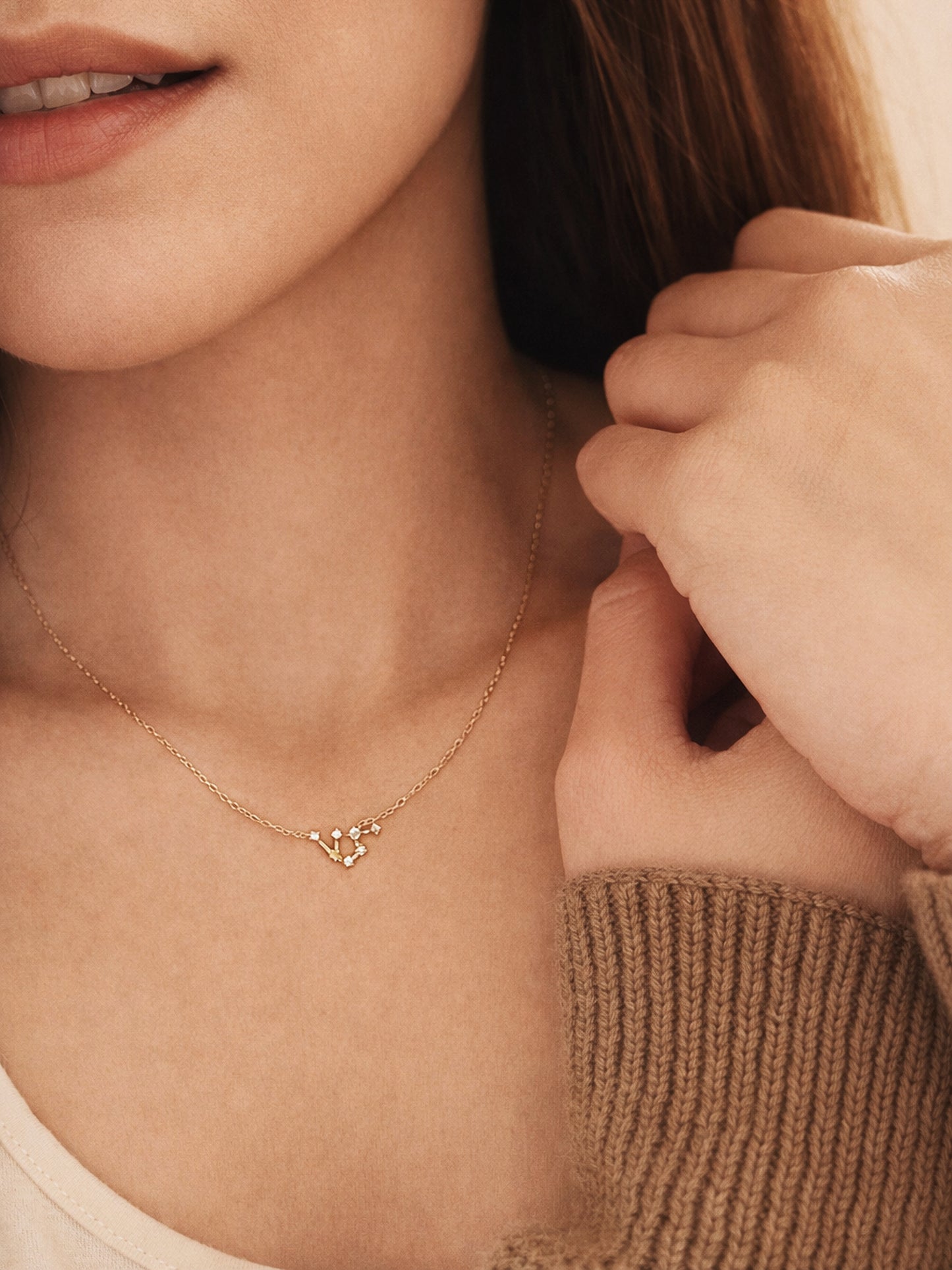 Close-up of a woman wearing a dainty gold Aquarius necklace, showcasing the luxury aesthetic and pendant scale. Crafted in 14k gold vermeil.