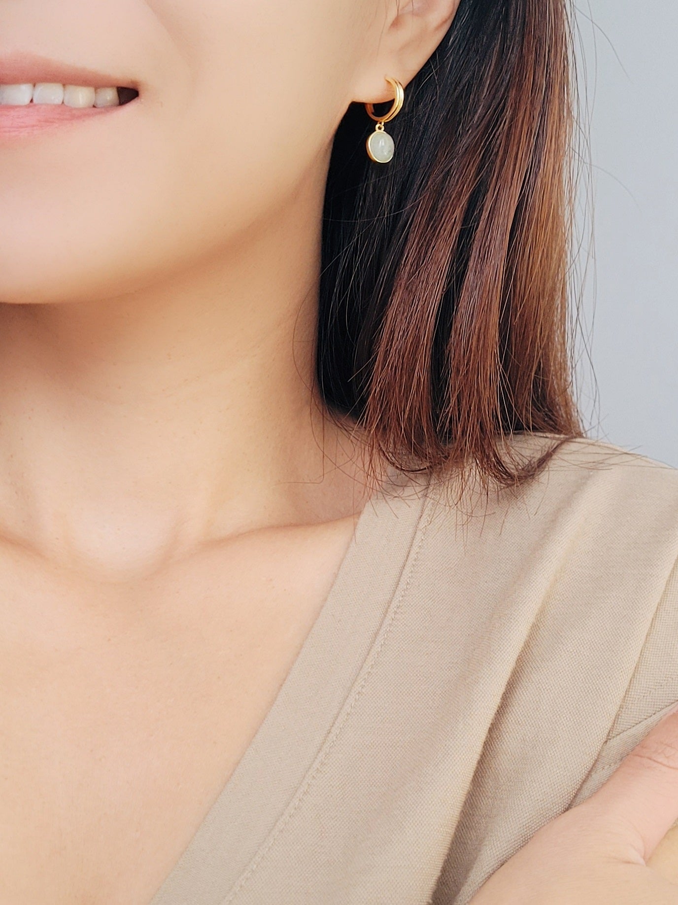 A woman displays a stunning gold aventurine drop earrings, emphasizing the charm of natural gemstones.