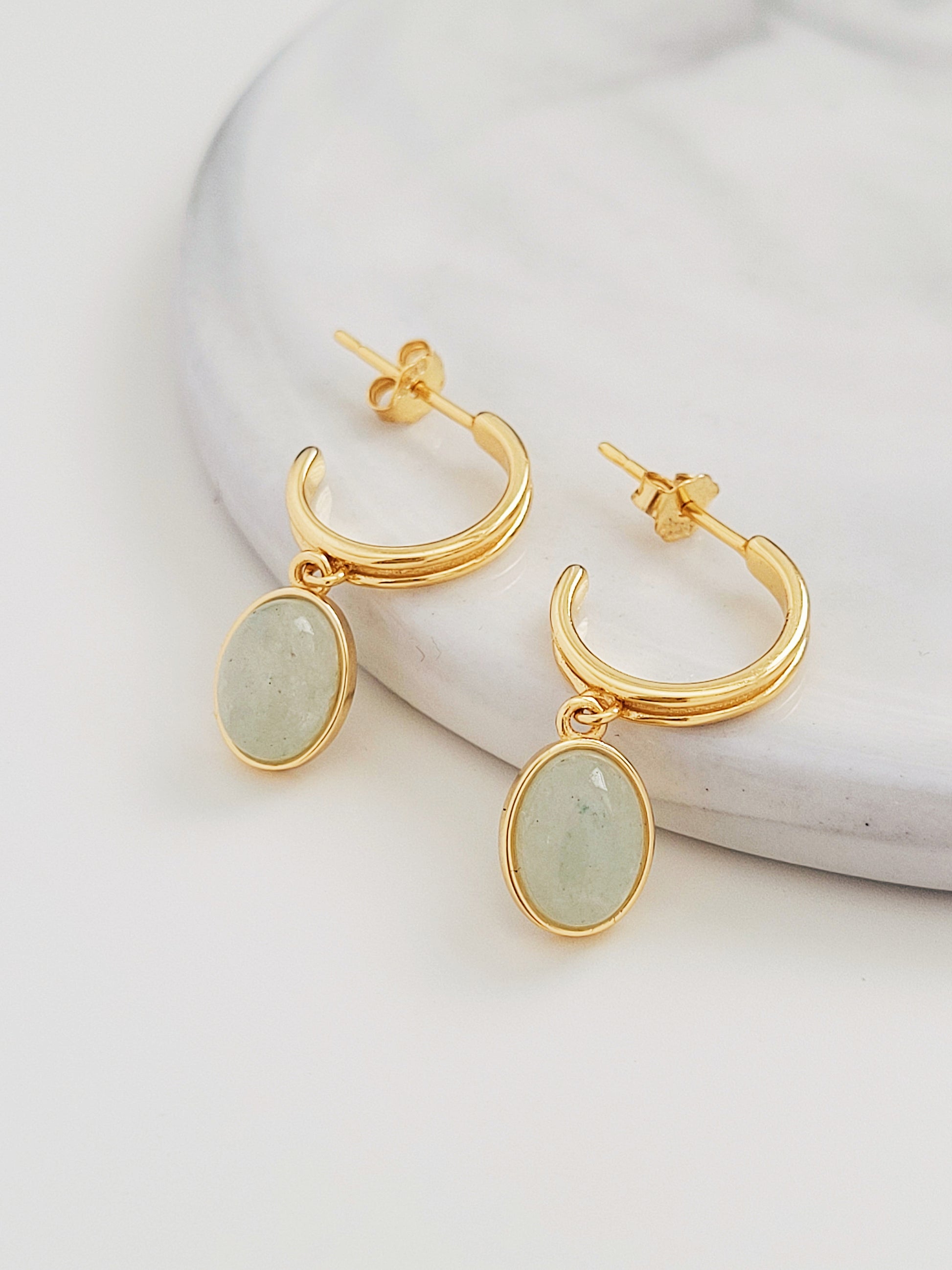 Elegant gold hoop earrings adorned with natural aventurine stones, exuding sophistication and timeless beauty.