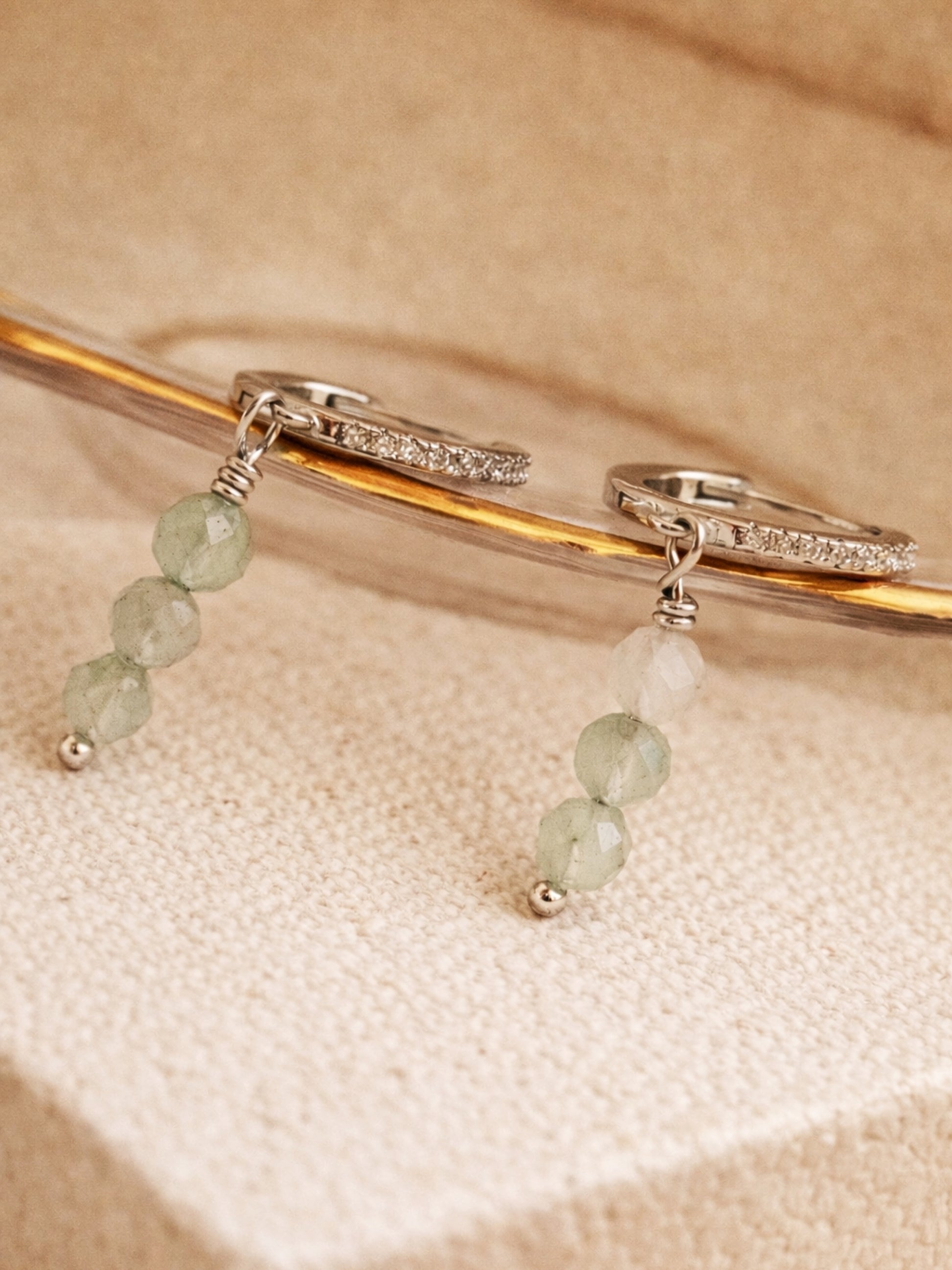 Pair of earrings with green aventurine beads on silver hoops.