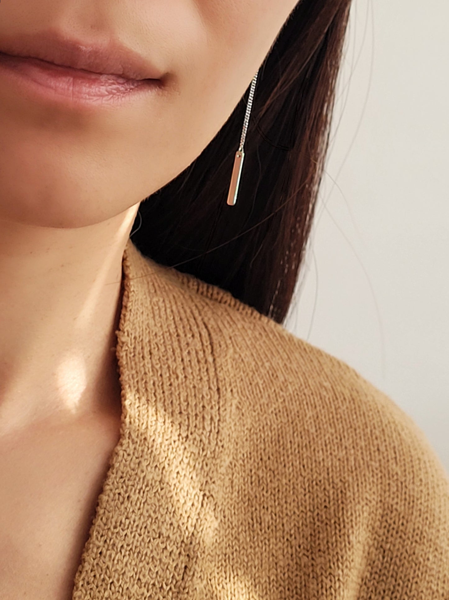 Model wearing a sterling silver bar dangle earring.