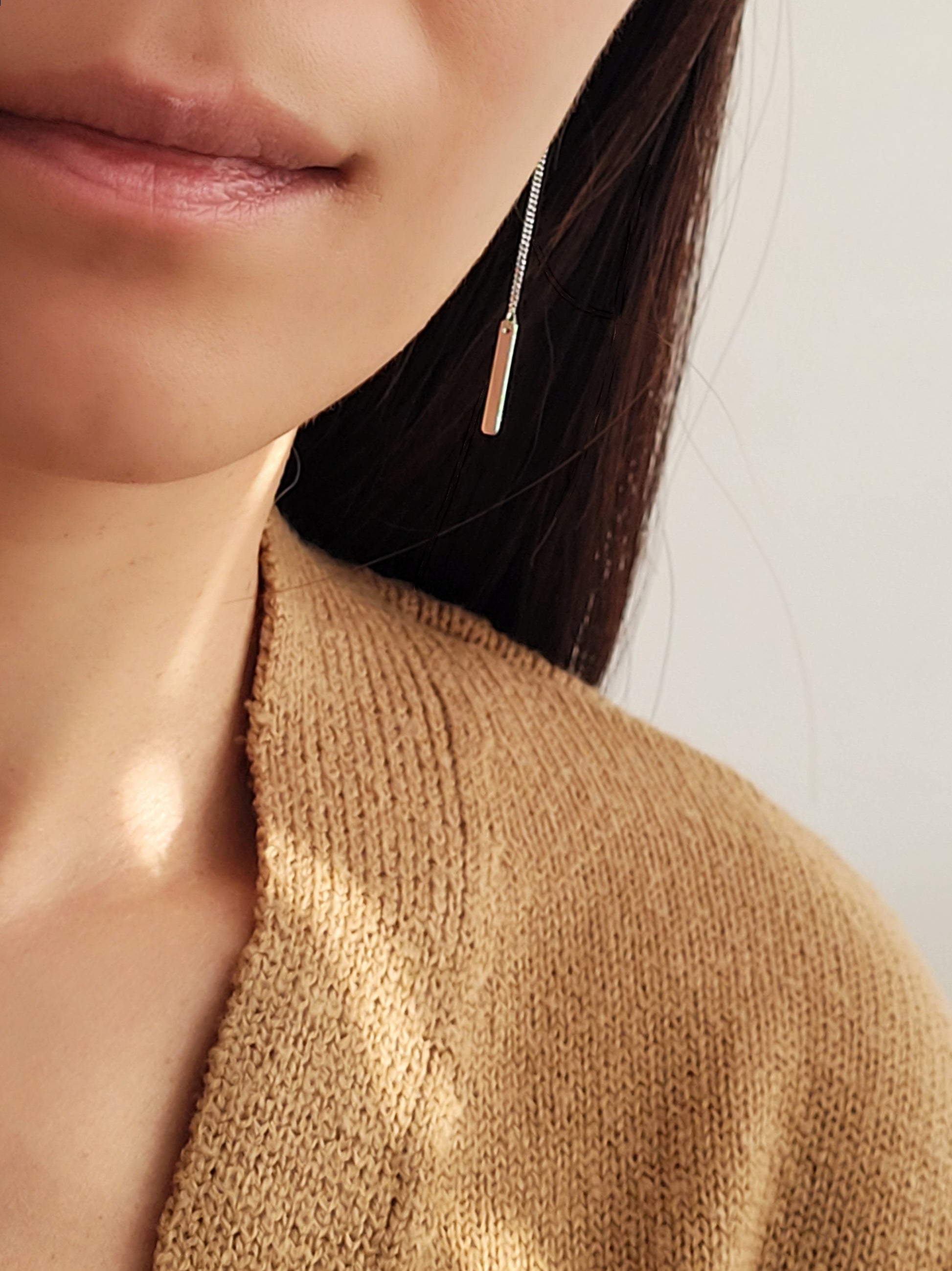 Model wearing a sterling silver bar dangle earring.