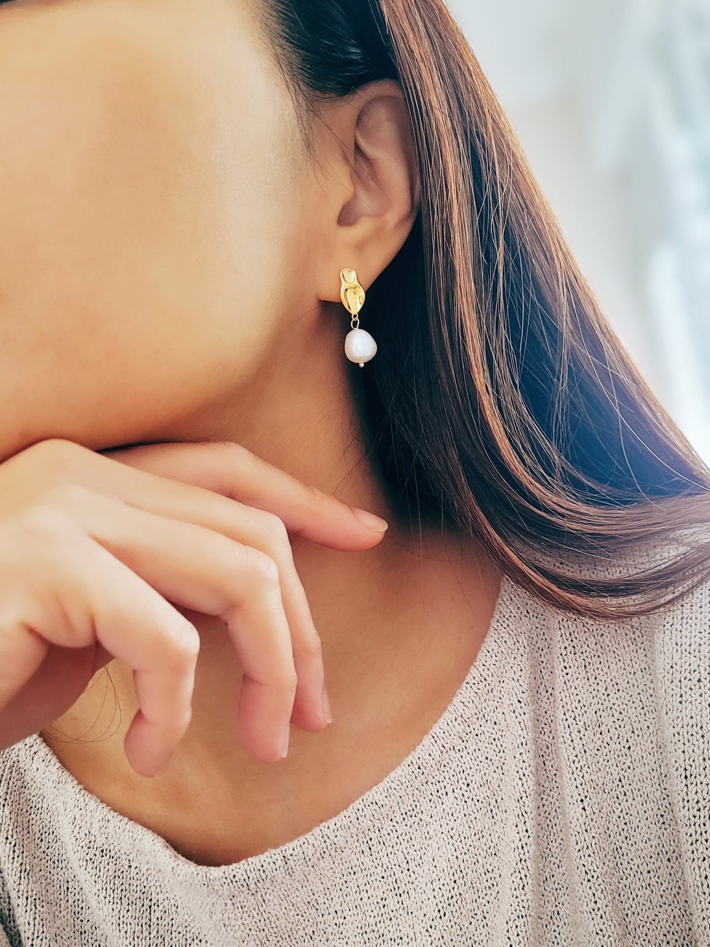 Stylish freshwater pearl earring with a gold drop setting, perfect for formal occasions.