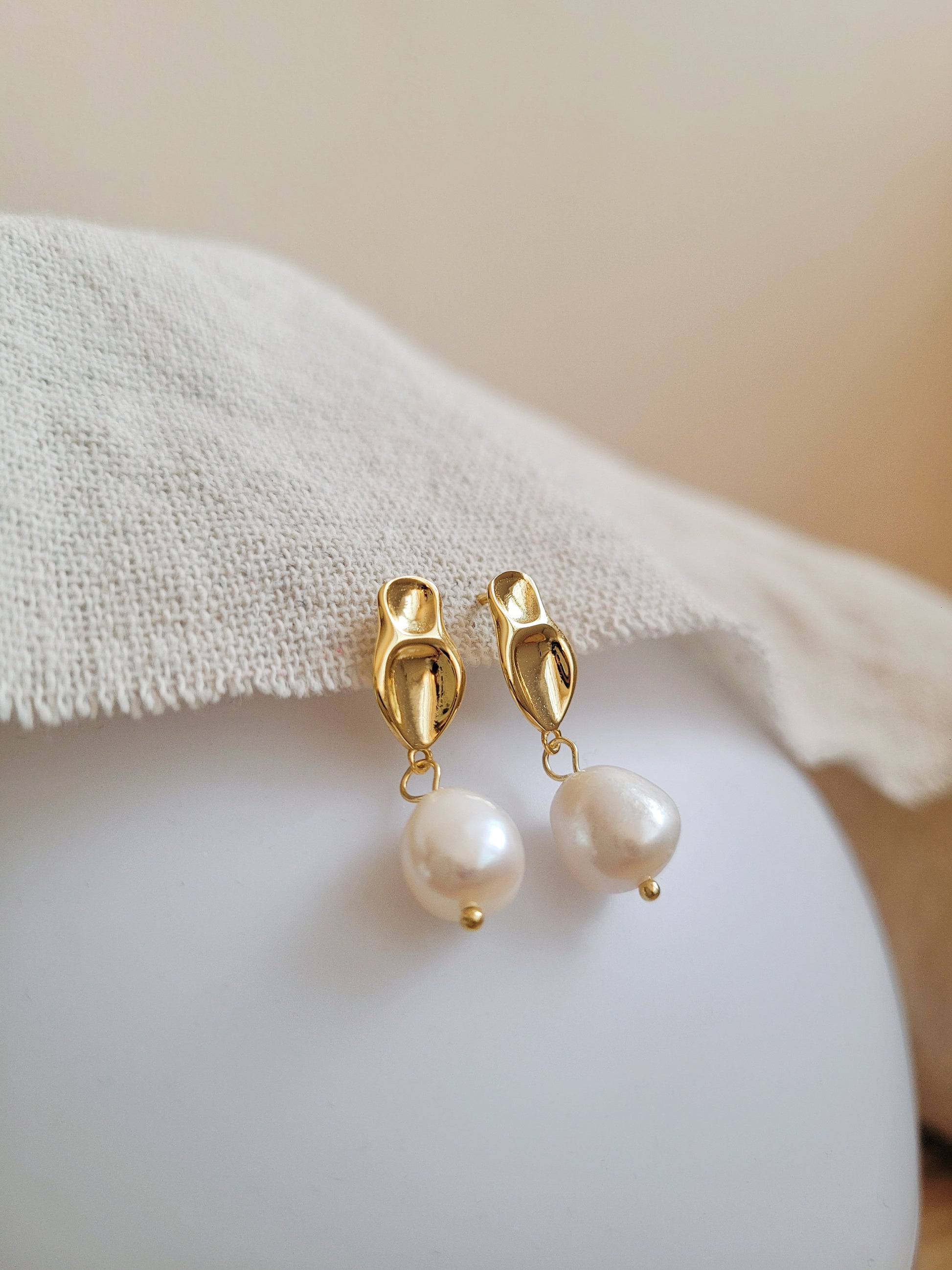 Elegant freshwater pearl dangle earring in gold, highlighting a modern, minimalistic design.